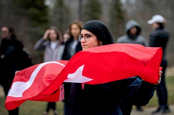 A college student holds a red Turkish flag during a vigil.  