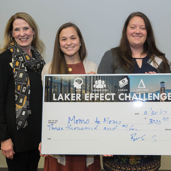 four women holding big check