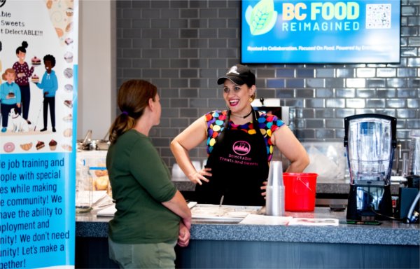 a cafe counter, woman working behind, customer in front