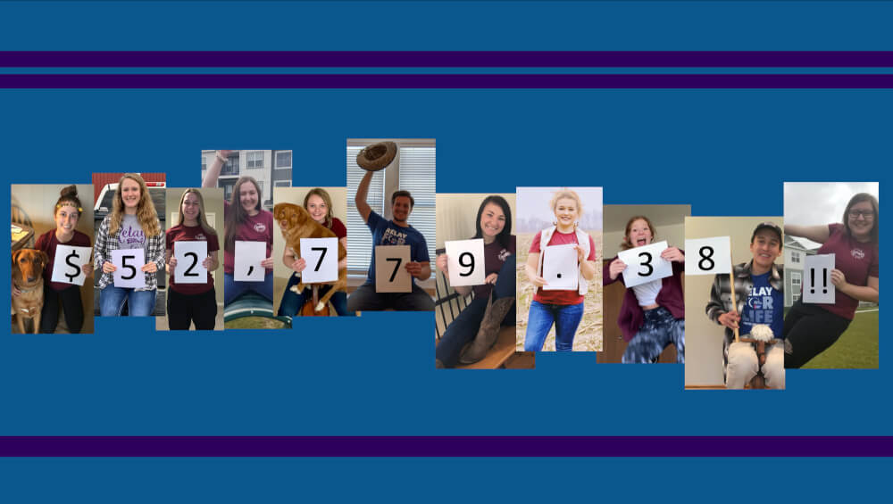 Students hold up signs with numbers to reflect the amount of money raised.