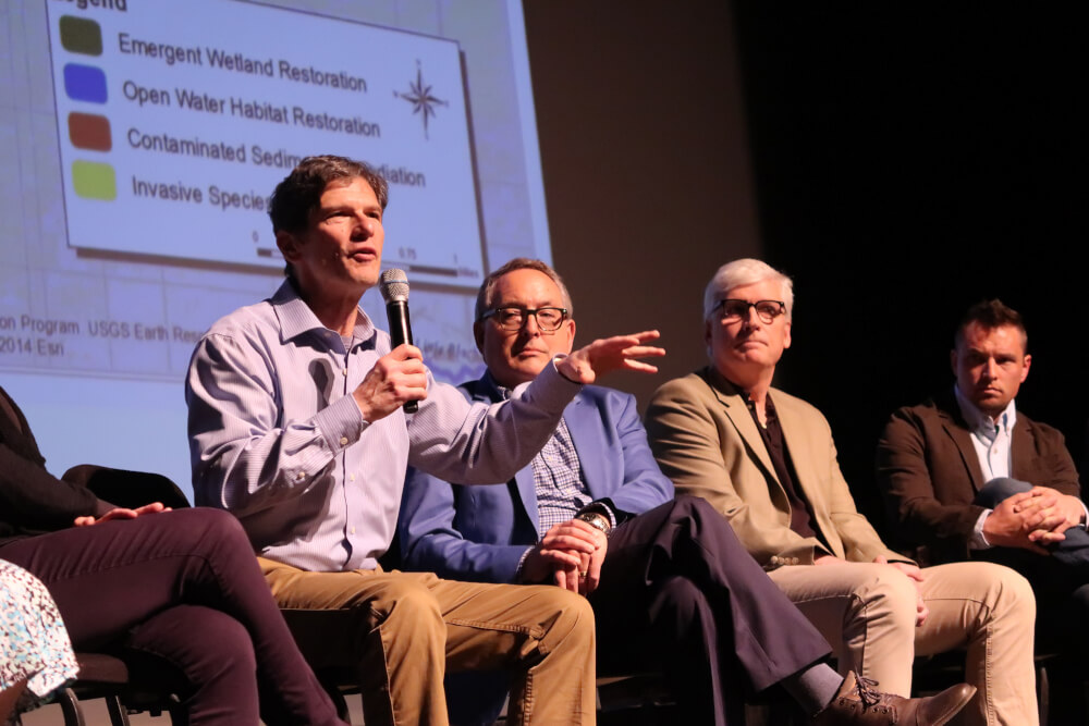 Alan Steinman, director of the Annis Water Resources Institute, at left, speaks during a panel discussion. Director David Ruck, far right, listens.