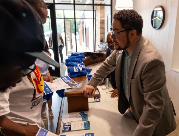 Danny Vélez hands out GVSU gear to attendees at a Detroit Achievement Academy eighth grade promotion ceremony