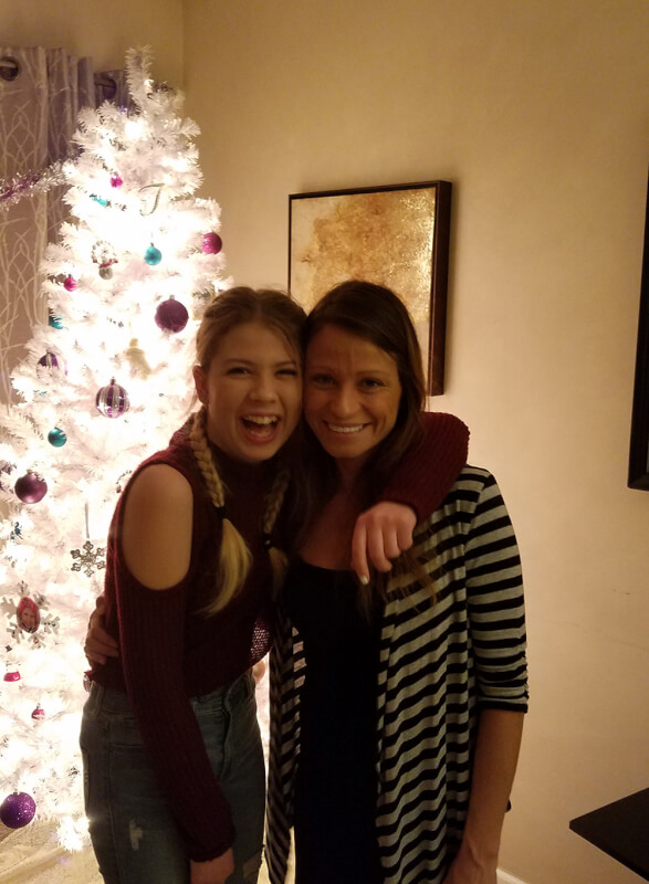 two women standing in front of Christmas tree