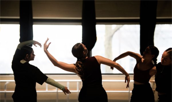 Dancers hold their arms in different poses.