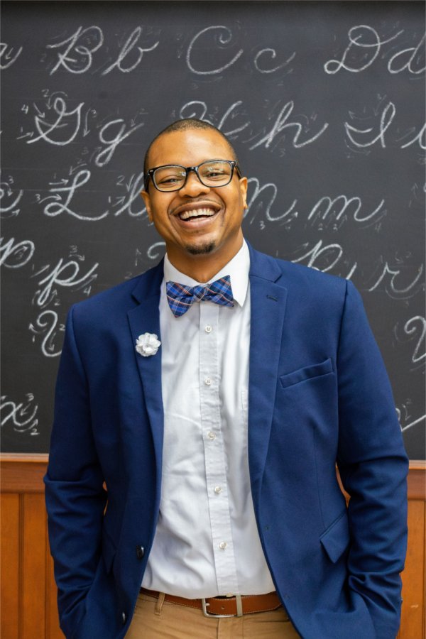 Dar Mayweather standing in front of chalkboard