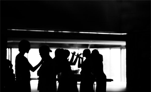 Dancers are silhouetted against a large window.  