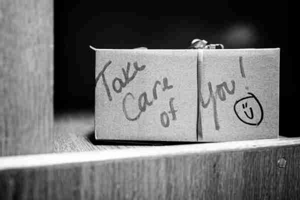 Black and white photo of sticky notes that read "Take care of you!" 