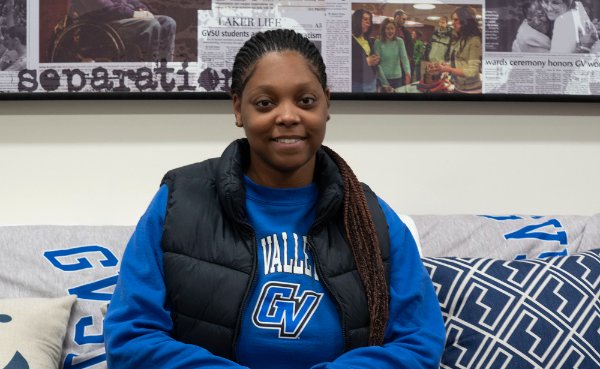 Kaiya Smith sits on a coach in the Office of Multicultural Affairs, she is wearing a blue sweatshirt and black vest