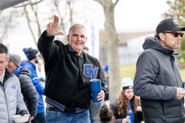 An Alumni holds up a Laker "L" during the Homecoming tailgate. 