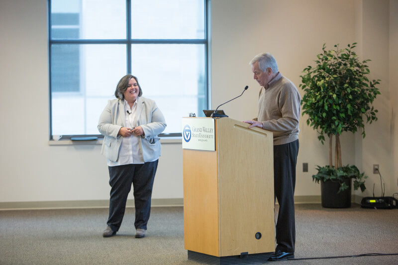 Man at podium introducing woman
