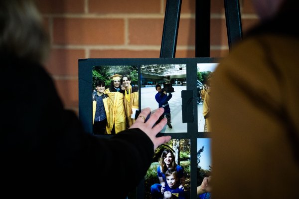 Image of a hand touching printed photos of Brendan Santo.