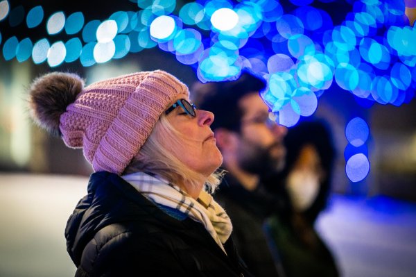 Image of a person with their eyes closed wearing a pink hat.