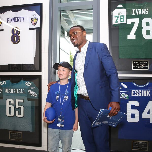 football player standing next to young boy