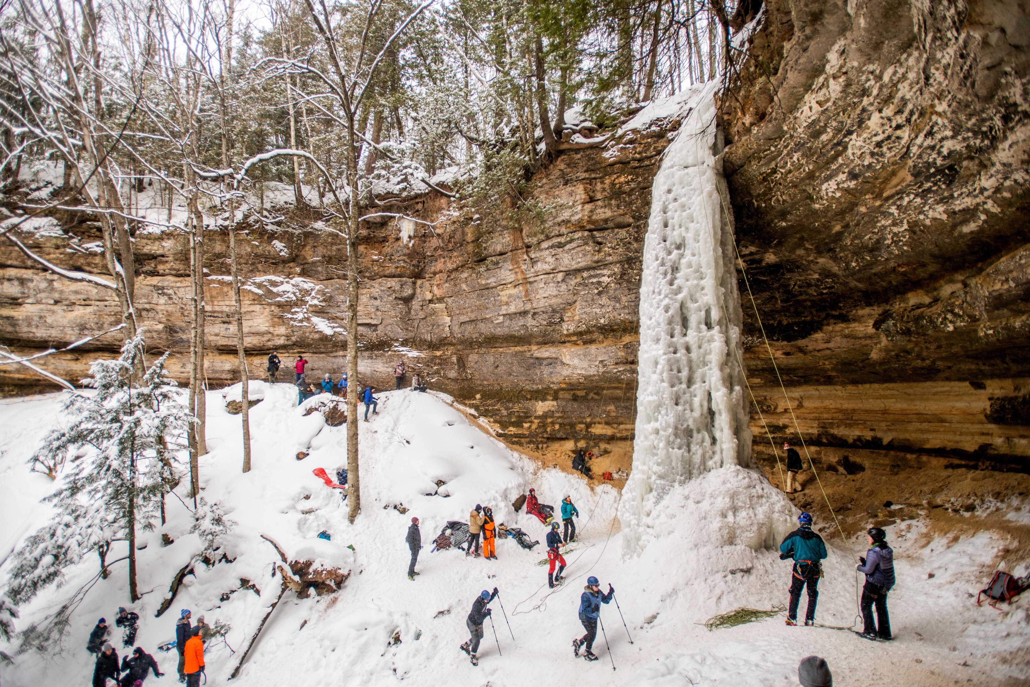 A crowd of ice climbers stand near the Dryer Hose climb during Ice Fest.