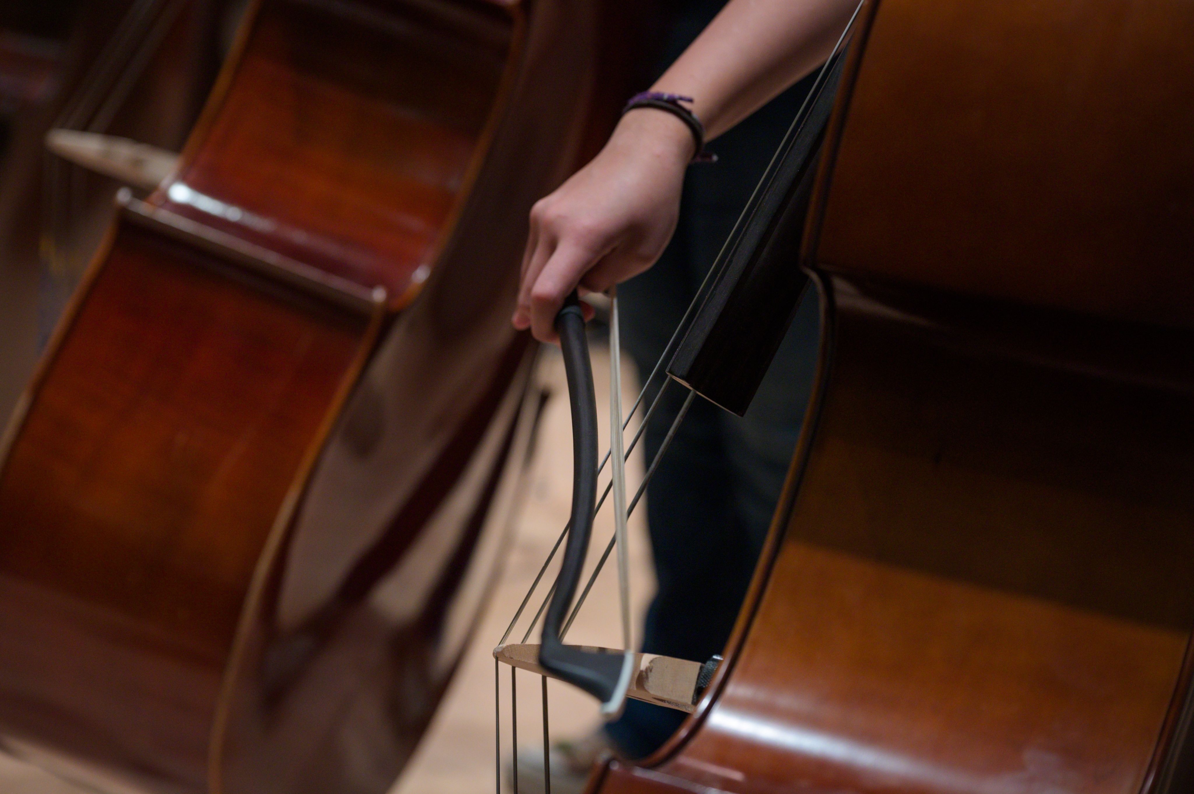 close up of right hand with bow and cello