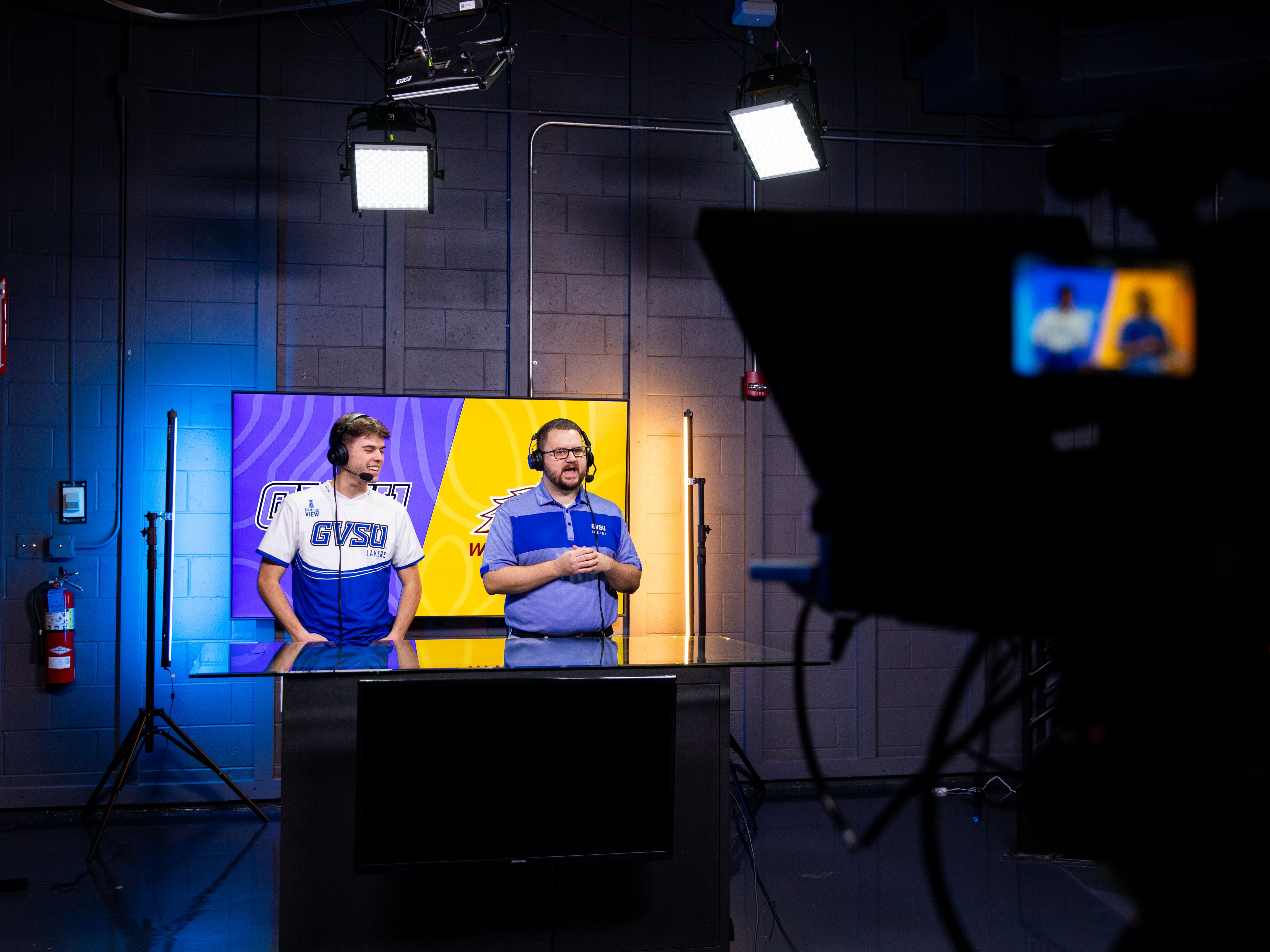 two people stand and broadcast games