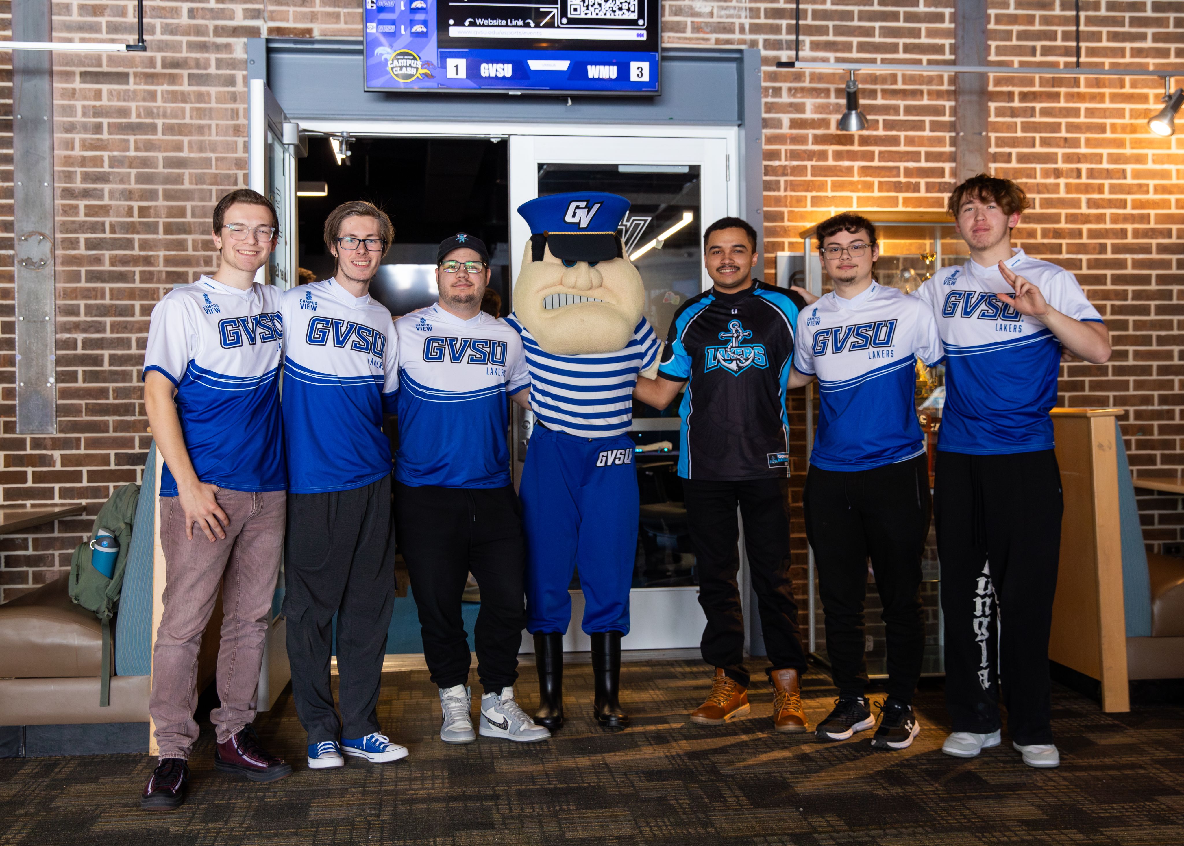 Louie the Laker in the middle of a group photo of six students all in GVSU shirts