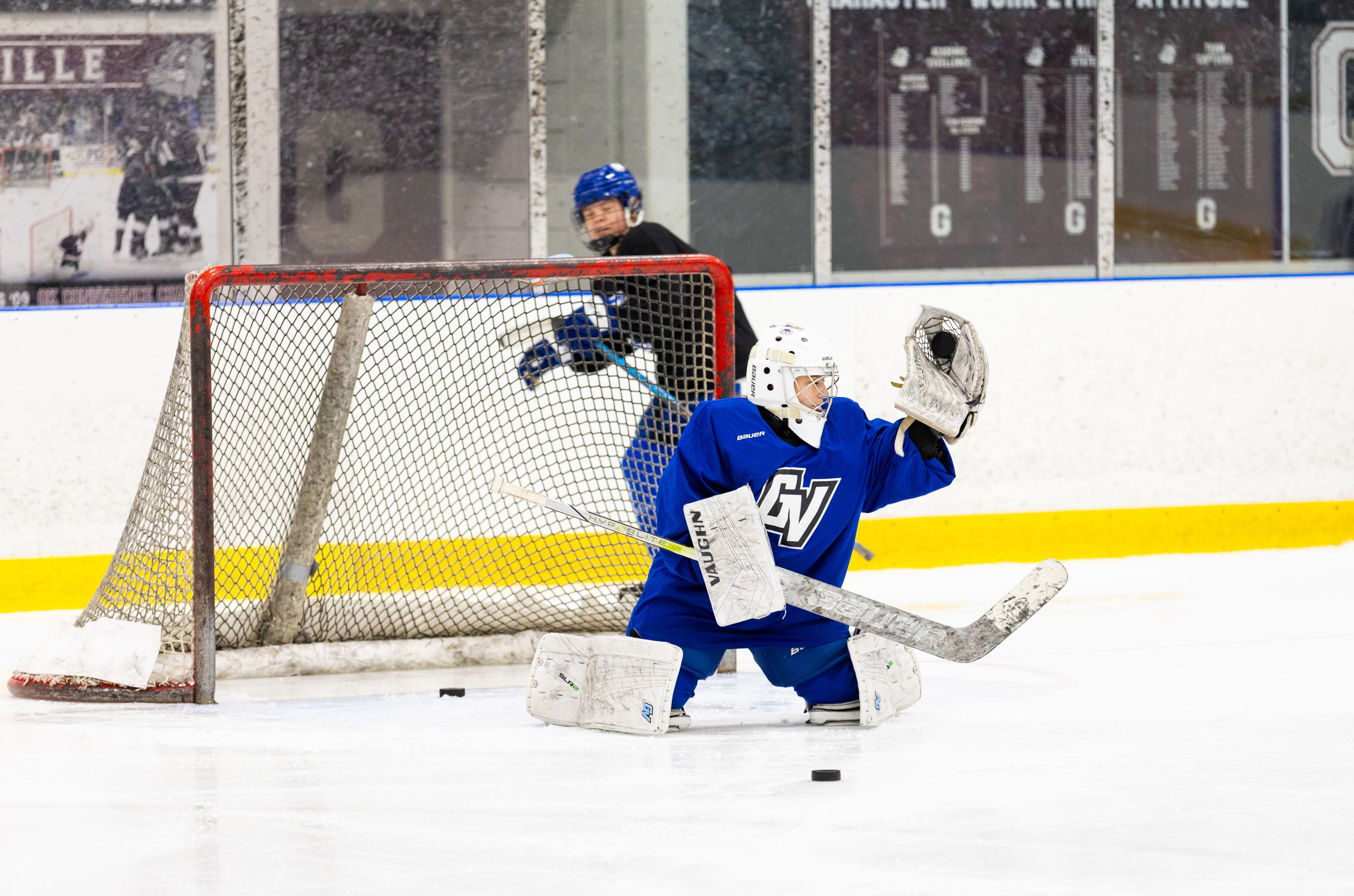 A hockey goalie catching a puck in their glove.