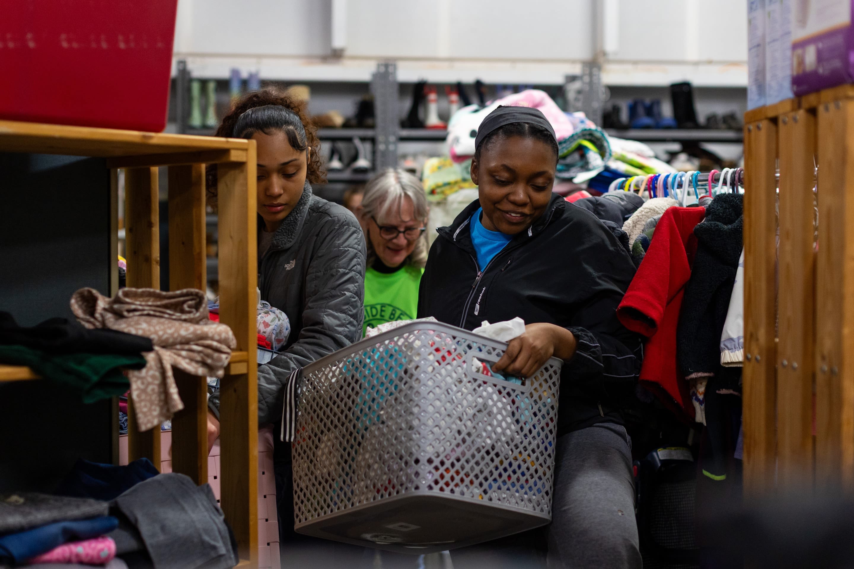 From left, Alizé Gonzalez (a freshman Nursing student), Nile Stewart (a junior in Social Work) and ABCCM volunteer Debra Luther carry clothes.