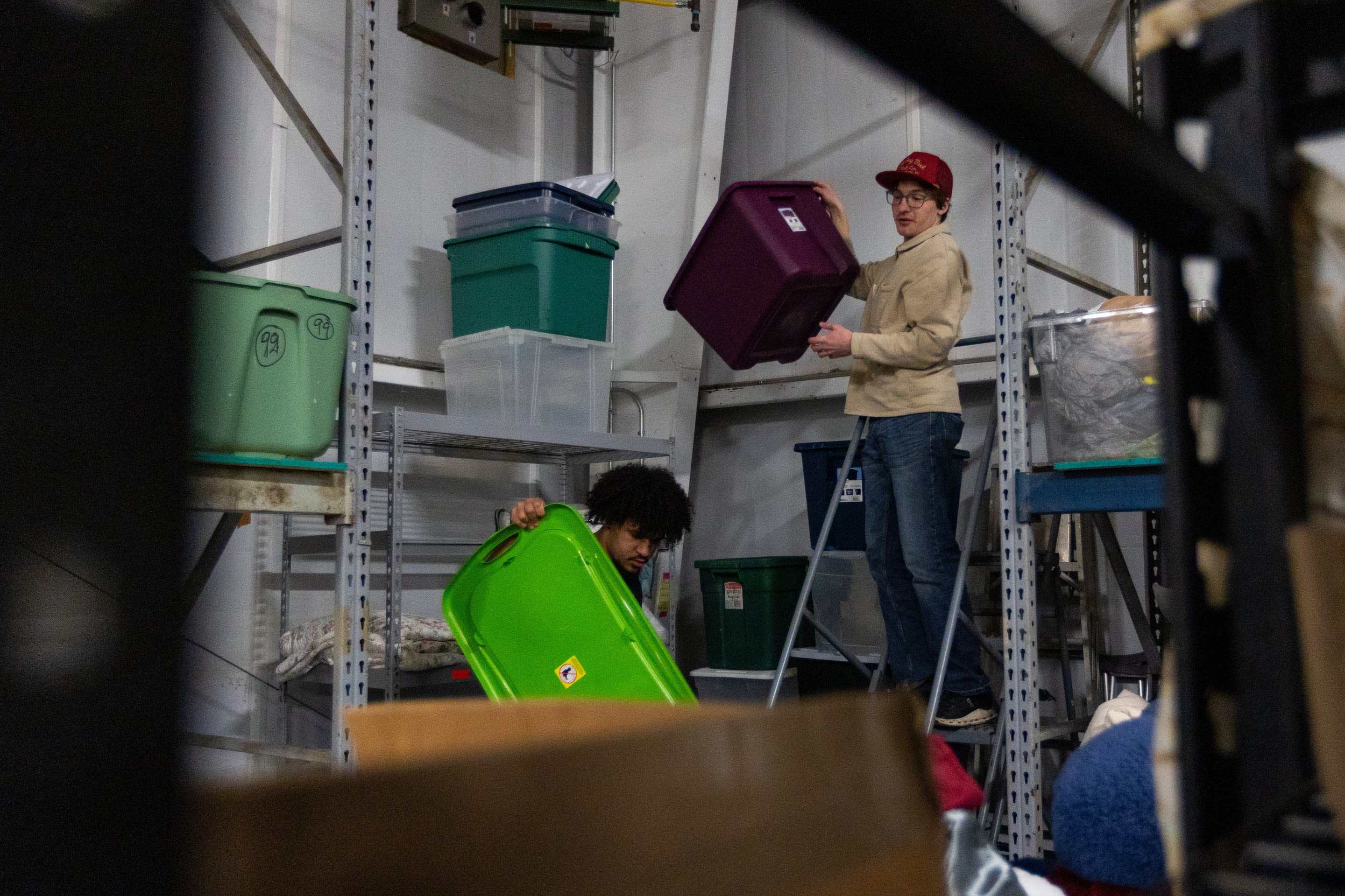 From left, Solomon Dukes, a senior majoring in Political Science, and Oliver Shampine, a junior studying Public and Nonprofit Administration, maneuver storage bins.