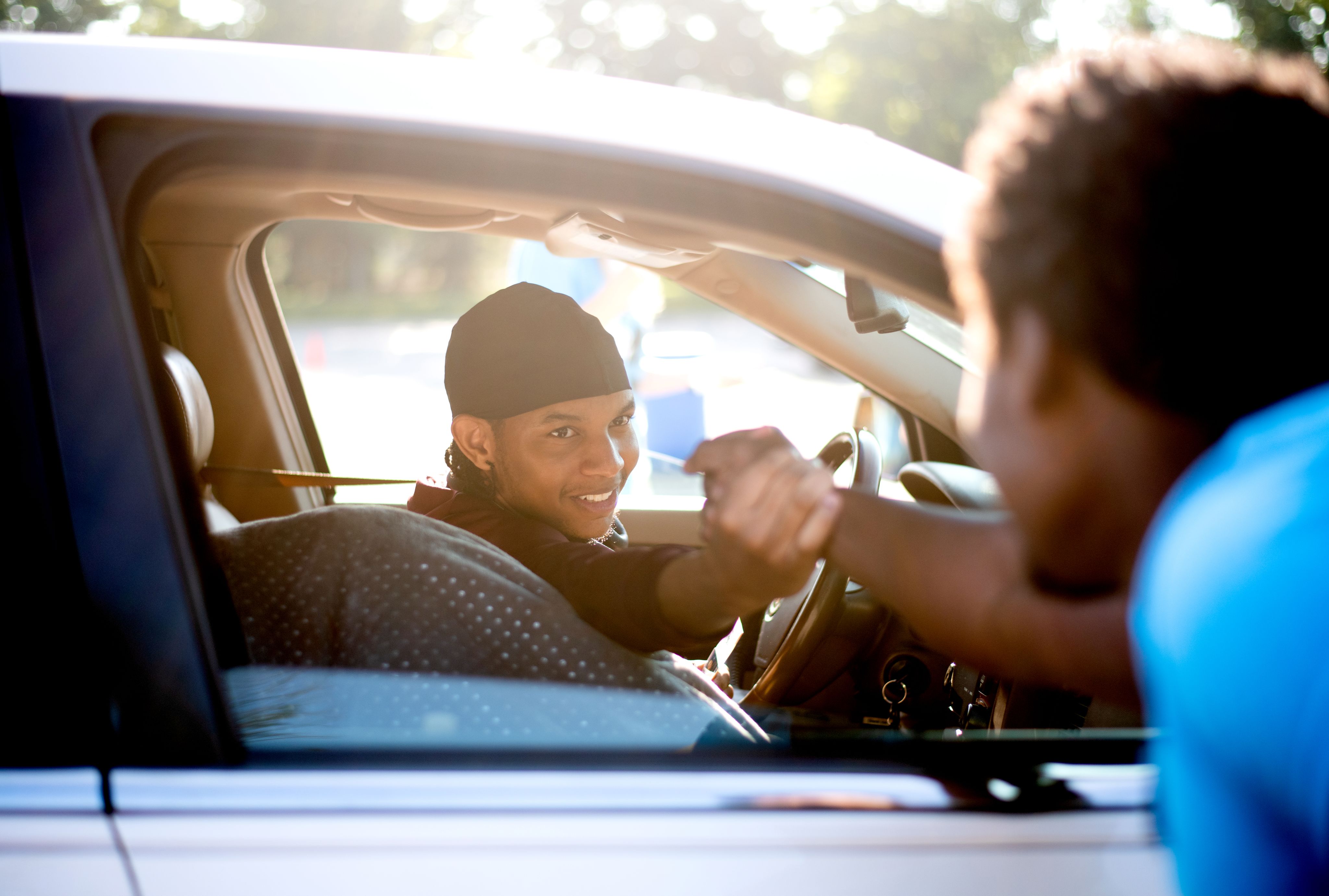 student getting a welcome handshake from his car on move in day