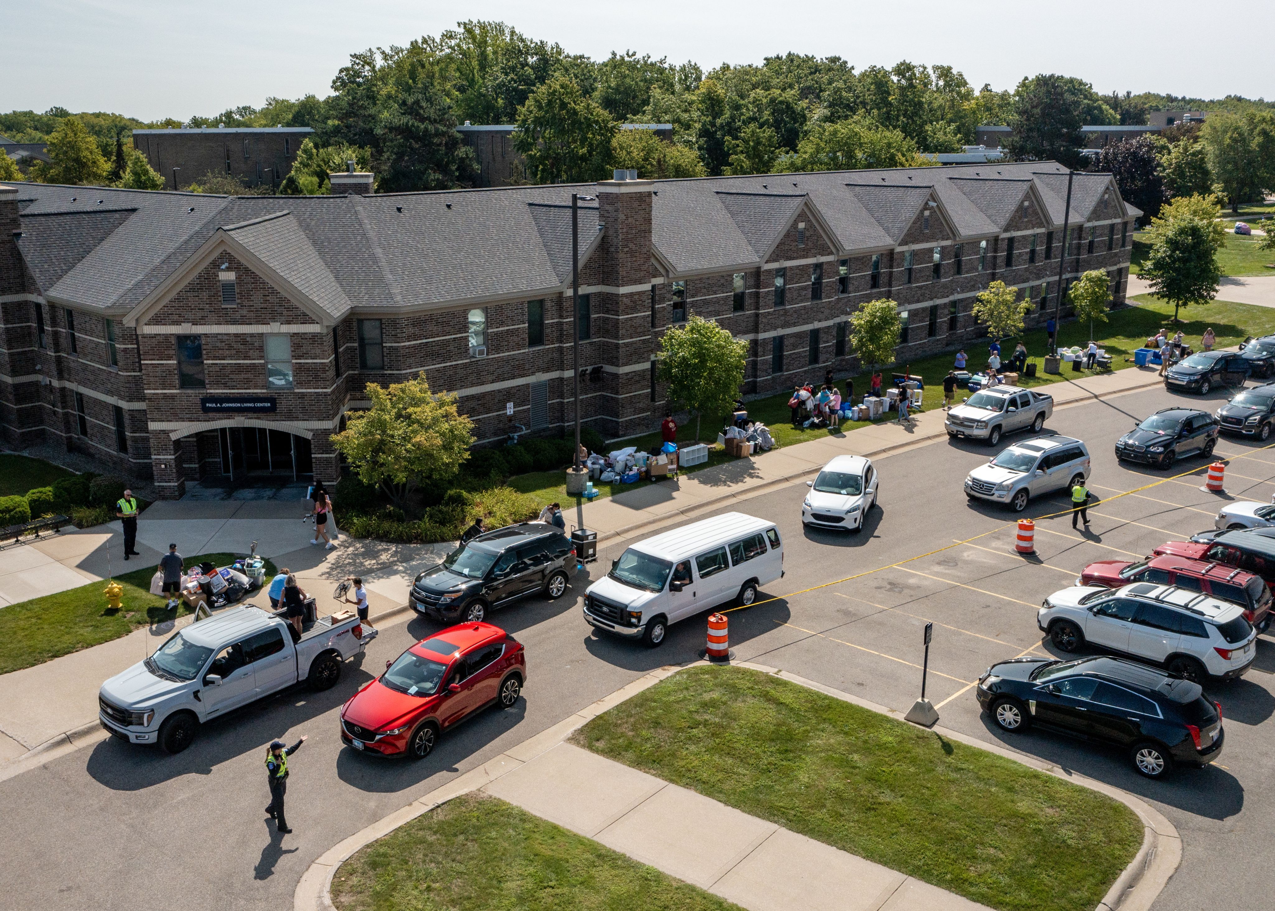 GVSU living center exterior with several cars parked out front during move-in